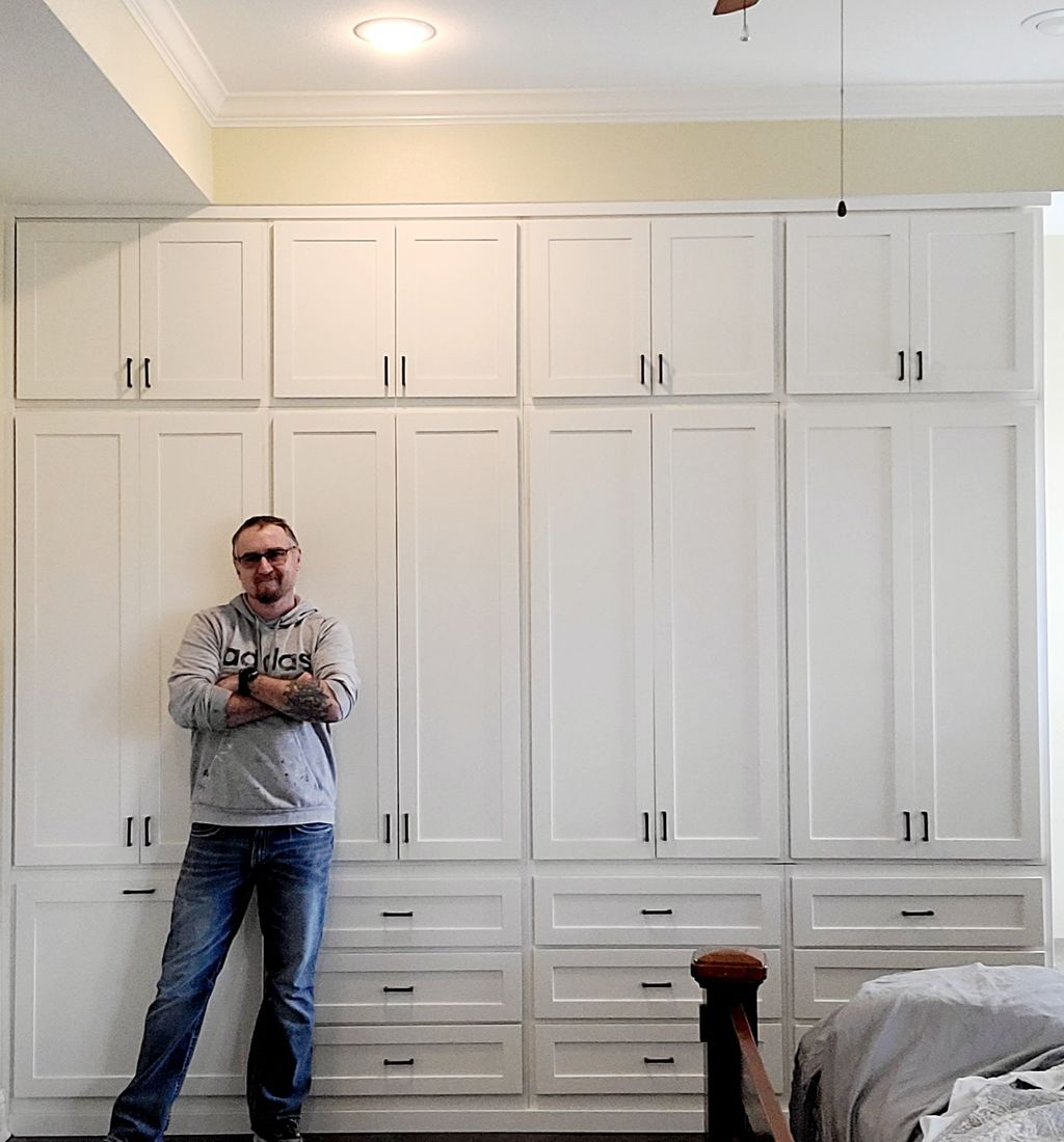 Christopher Webb standing in front of a custom closet wall he built