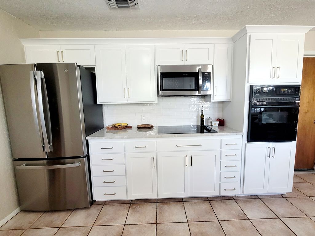 The same range wall after refacing with white Shaker doors, drawer fronts and updated hardware