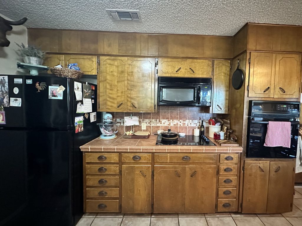 Range wall before refacing with dated wood cabinet doors and drawer fronts